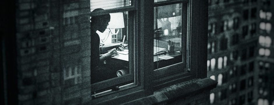 a woman edits a document in a lighted window